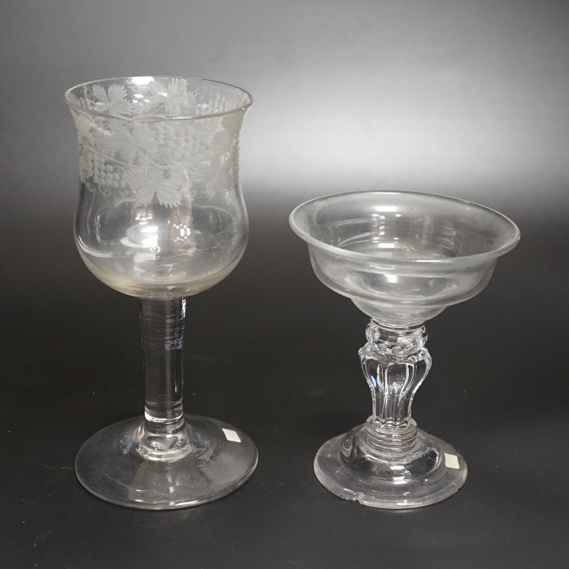 Two champagne or sweetmeat glasses c.1740, with double ogee bowls, the taller example with etched vines around bowl and plain stem, the shorter example with collar under the bowl, over a eight sided moulded pedestal stem
